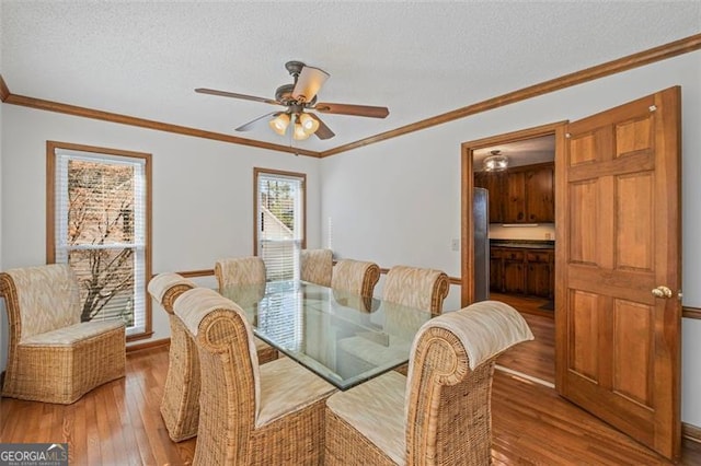 dining area with ornamental molding, a textured ceiling, ceiling fan, and hardwood / wood-style flooring