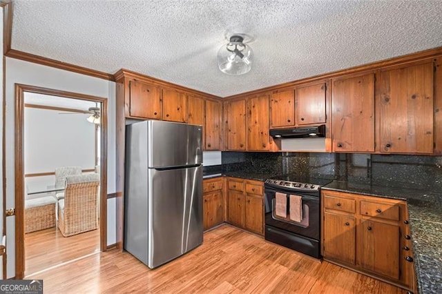 kitchen featuring light wood-style flooring, under cabinet range hood, freestanding refrigerator, black / electric stove, and brown cabinetry