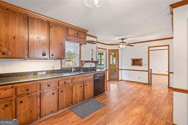 kitchen with dark countertops, black dishwasher, brown cabinets, light wood-style flooring, and a sink