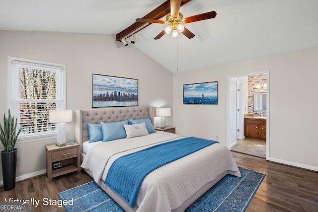 bedroom featuring ensuite bathroom, baseboards, wood finished floors, and vaulted ceiling with beams