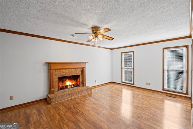 unfurnished living room with wood finished floors, a fireplace, and ornamental molding