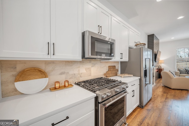 kitchen with white cabinetry, light countertops, light wood-style flooring, and appliances with stainless steel finishes