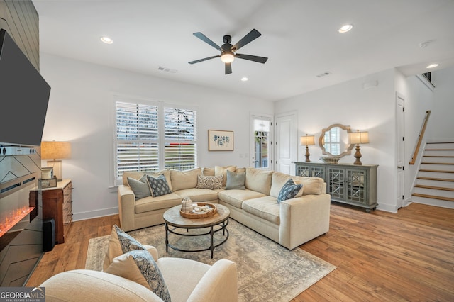 living area featuring recessed lighting, stairway, light wood-style flooring, and ceiling fan