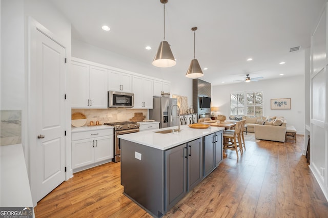 kitchen featuring visible vents, a sink, gray cabinetry, stainless steel appliances, and white cabinetry