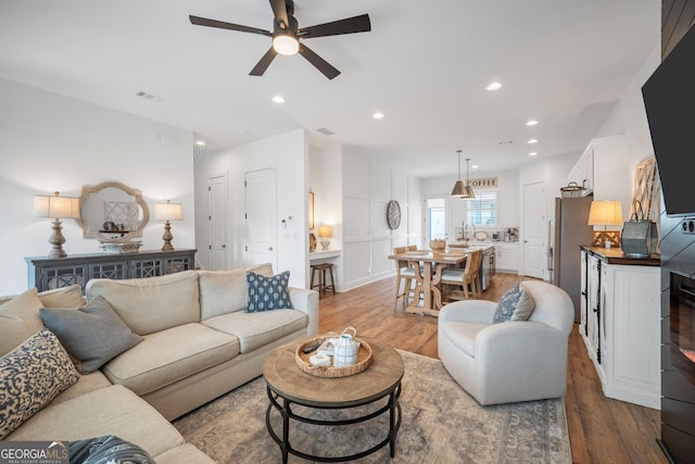 living area featuring recessed lighting, visible vents, wood finished floors, and ceiling fan