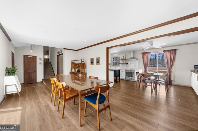 dining area featuring recessed lighting, ornamental molding, stairs, and wood finished floors