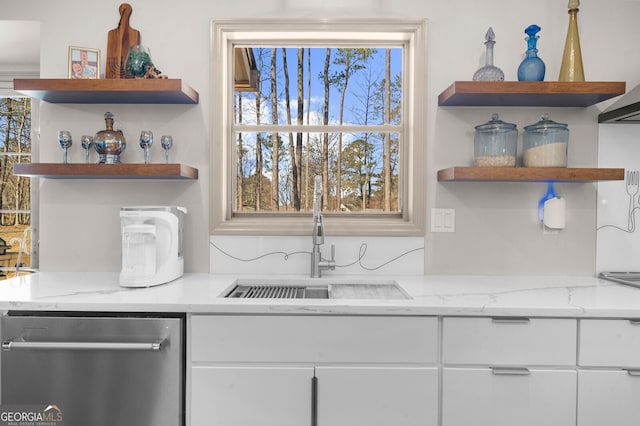 kitchen featuring stainless steel dishwasher, open shelves, plenty of natural light, and a sink