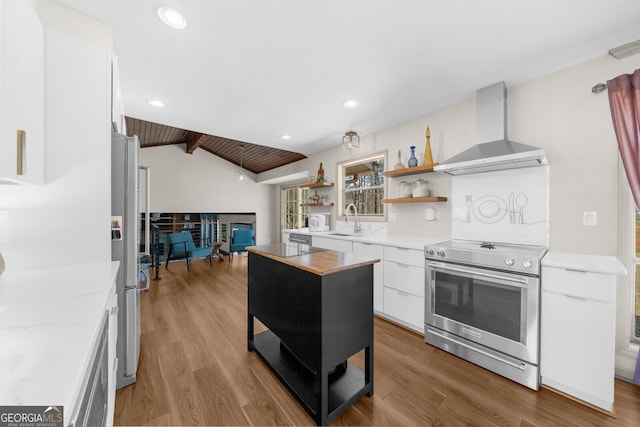 kitchen featuring open shelves, a sink, white cabinets, appliances with stainless steel finishes, and wall chimney exhaust hood