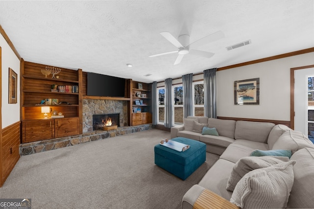 living room with built in features, visible vents, carpet floors, and a textured ceiling