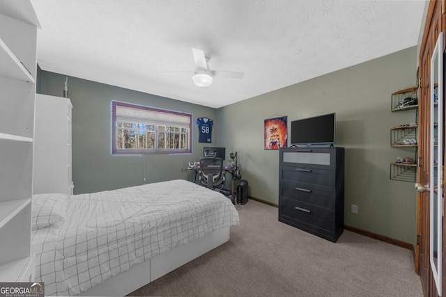 carpeted bedroom with a textured ceiling, baseboards, and a ceiling fan