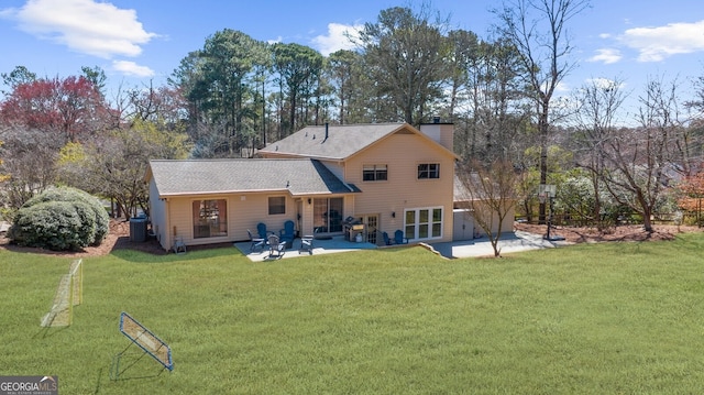 rear view of property with a yard, a patio area, and a chimney