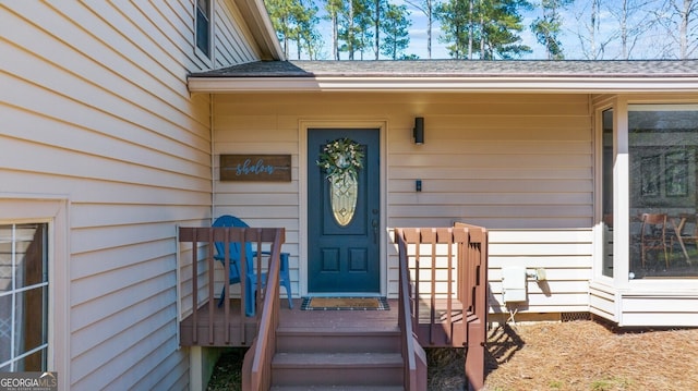 doorway to property featuring a shingled roof