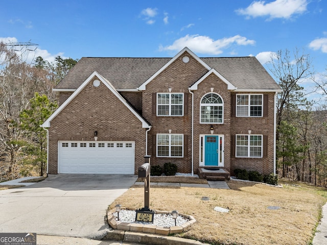 colonial-style house with driveway, brick siding, an attached garage, and a shingled roof