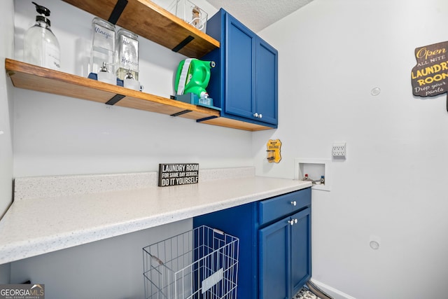 laundry area with cabinet space, a textured ceiling, and washer hookup