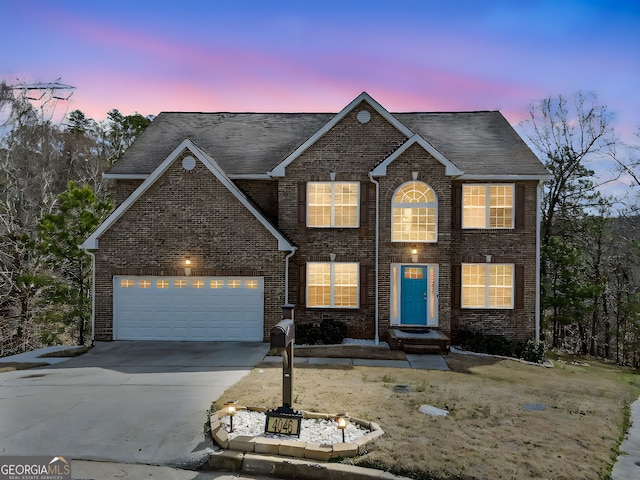 view of front facade with brick siding, an attached garage, and driveway