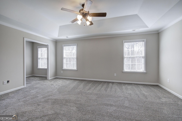 unfurnished room featuring a raised ceiling, a healthy amount of sunlight, visible vents, and ceiling fan