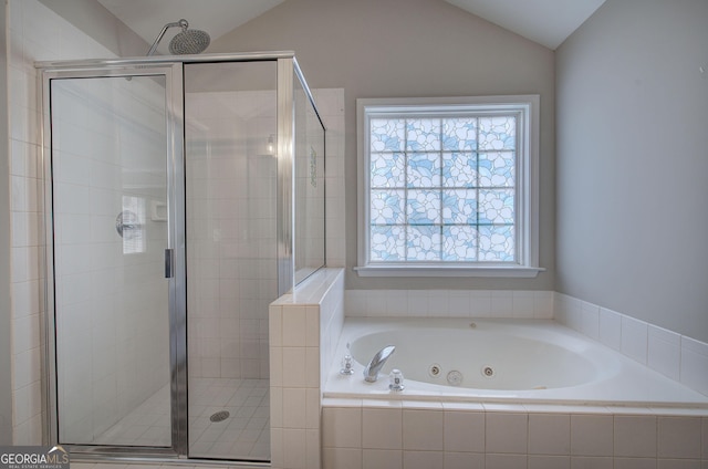 full bathroom featuring a whirlpool tub, a shower stall, and vaulted ceiling