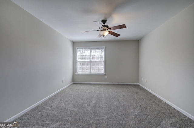 carpeted empty room with a ceiling fan and baseboards