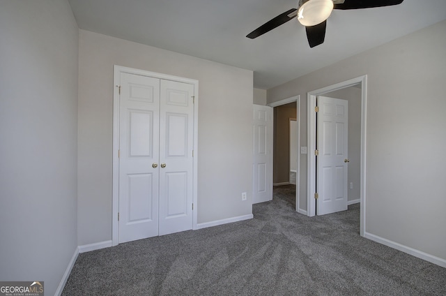 unfurnished bedroom featuring baseboards, dark colored carpet, a closet, and ceiling fan