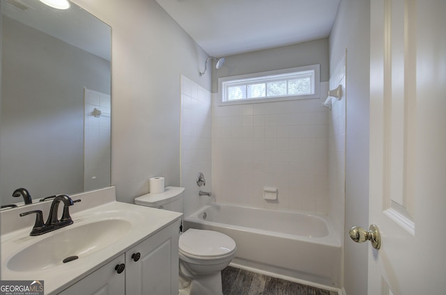 bathroom featuring visible vents, toilet, wood finished floors, vanity, and  shower combination