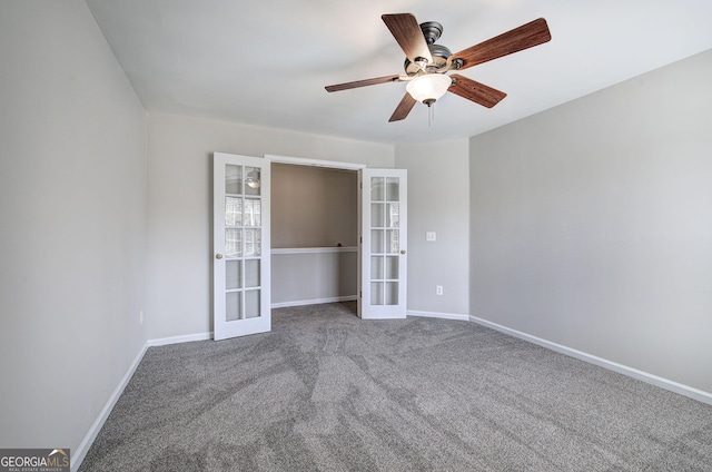 carpeted spare room featuring french doors, baseboards, and a ceiling fan