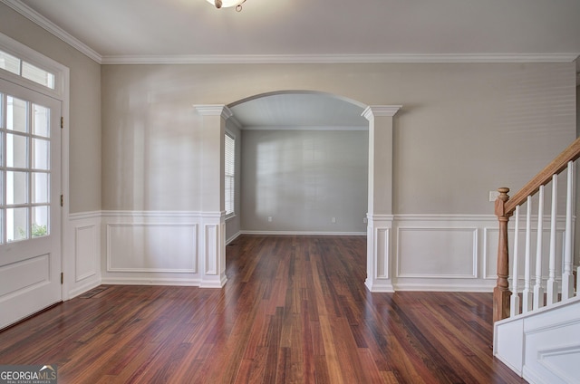 entryway with arched walkways, dark wood-style floors, stairway, and crown molding