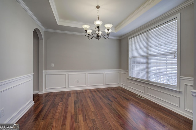 unfurnished room with dark wood-style floors, visible vents, arched walkways, a raised ceiling, and a chandelier