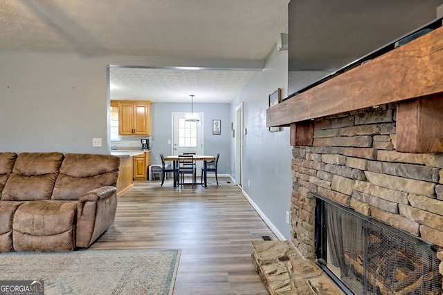 95 Volunteer Ln, Murphy, NC 28906 - living room featuring baseboards, light wood-style floors, and a stone fireplace