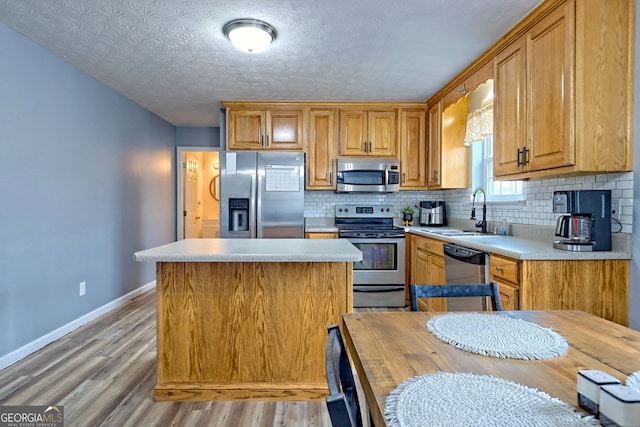 95 Volunteer Ln, Murphy, NC 28906 - kitchen with a kitchen island, a sink, light countertops, appliances with stainless steel finishes, and tasteful backsplash