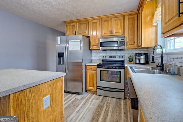 95 Volunteer Ln, Murphy, NC 28906 - kitchen featuring light wood-style flooring, a sink, light countertops, appliances with stainless steel finishes, and tasteful backsplash