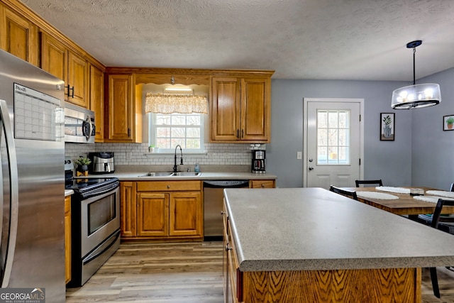 95 Volunteer Ln, Murphy, NC 28906 - kitchen featuring stainless steel appliances, light wood-style flooring, brown cabinets, and a textured ceiling