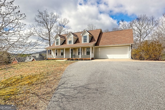 cape cod-style house featuring a porch, a garage, roof with shingles, and aphalt driveway