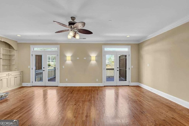 unfurnished room featuring crown molding, wood finished floors, french doors, and baseboards