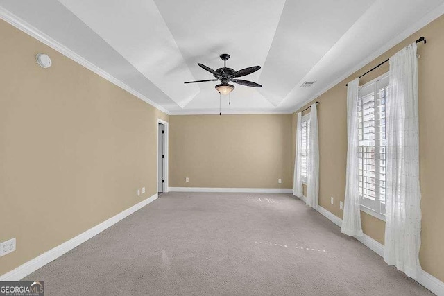 spare room with carpet, baseboards, visible vents, a tray ceiling, and ornamental molding