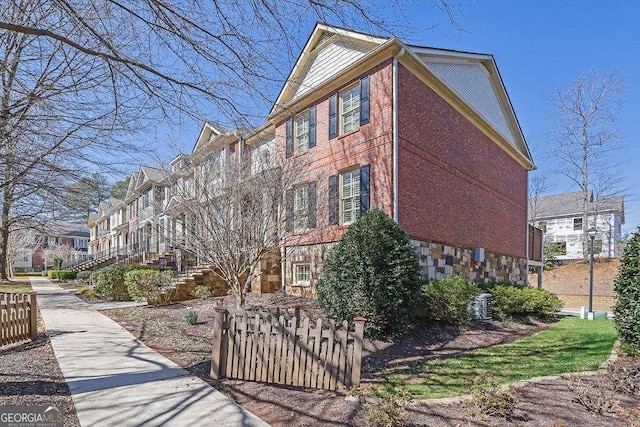 view of property exterior with stairway and stone siding