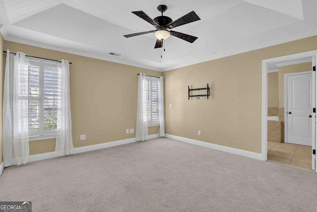 empty room with ceiling fan, a healthy amount of sunlight, visible vents, and light carpet