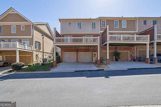 view of front facade with a garage, central air condition unit, brick siding, and driveway