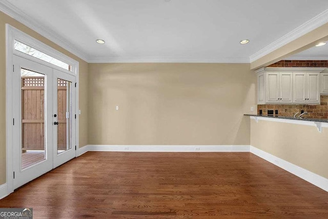 interior space with dark wood-type flooring, recessed lighting, crown molding, and baseboards