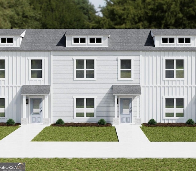 modern farmhouse style home with board and batten siding, a shingled roof, and a front lawn