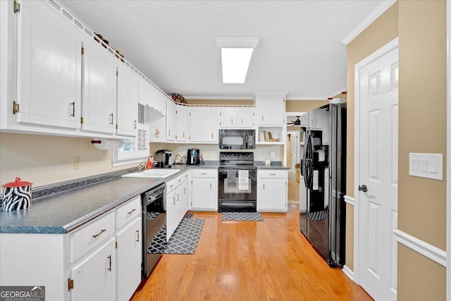 25 Wesley Trce SE, Cartersville, GA 30120 - kitchen with a sink, black appliances, white cabinets, light wood-style floors, and dark countertops