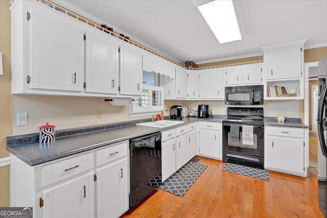 25 Wesley Trce SE, Cartersville, GA 30120 - kitchen with white cabinetry, black appliances, light wood finished floors, and a sink
