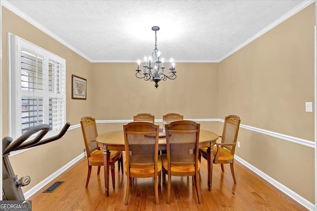 25 Wesley Trce SE, Cartersville, GA 30120 - dining room with light wood finished floors, visible vents, a notable chandelier, and ornamental molding