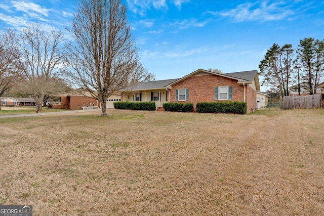 single story home featuring a front lawn, an attached garage, fence, and brick siding