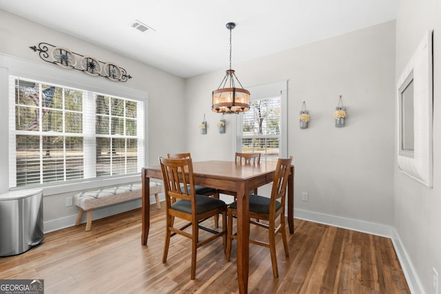 dining room featuring a wealth of natural light, visible vents, and wood finished floors