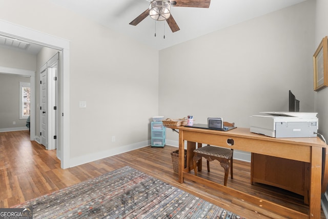 home office featuring visible vents, ceiling fan, baseboards, and wood finished floors