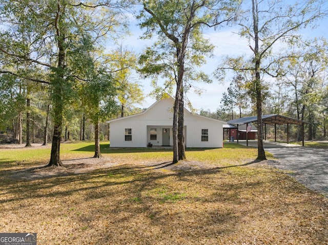 view of front of property with a detached carport, driveway, and a front lawn