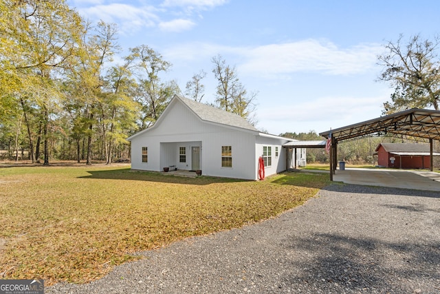 view of front of house featuring a detached carport, gravel driveway, and a front yard