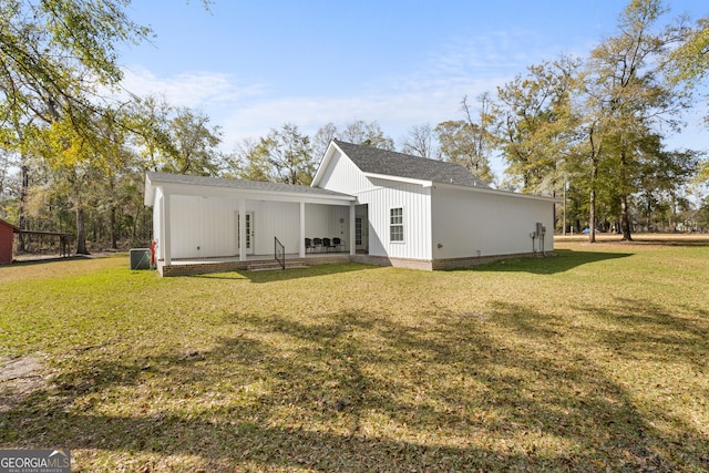 rear view of property featuring a lawn