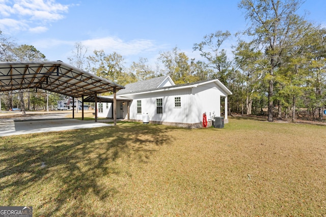 view of front of property featuring a carport, central AC unit, and a front lawn