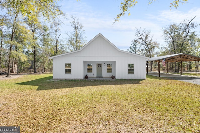 modern inspired farmhouse with a detached carport and a front lawn